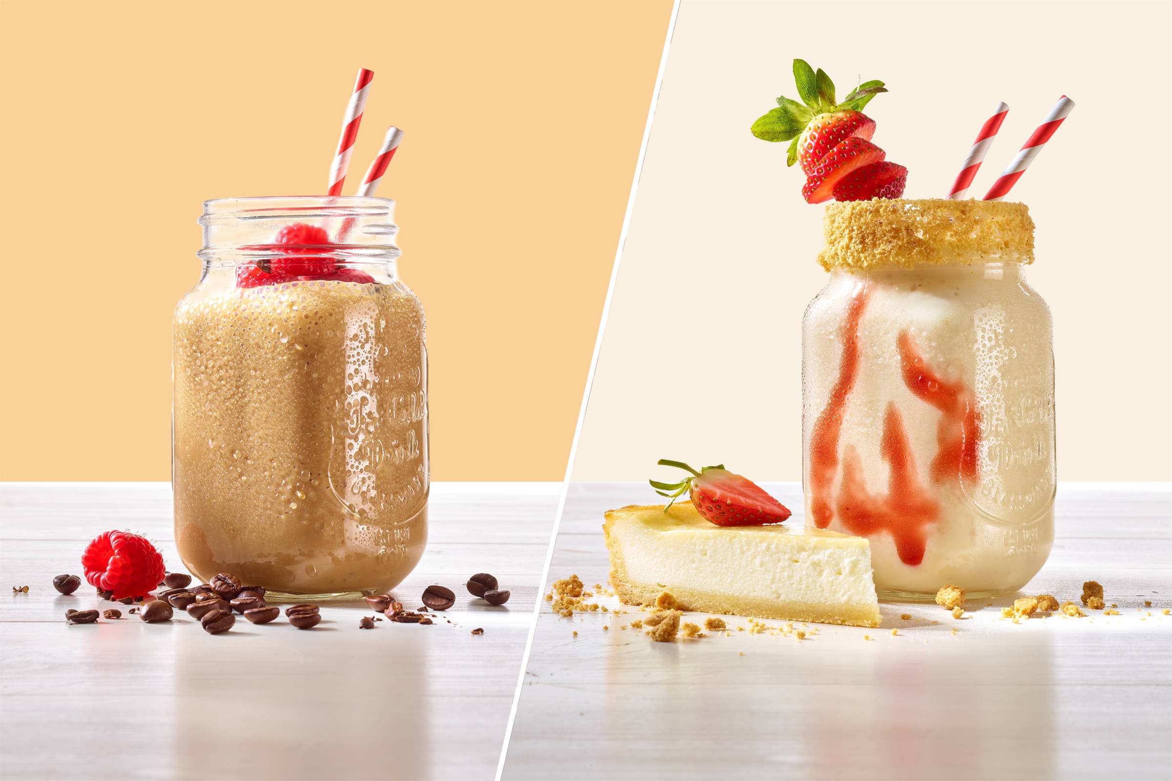 Zwei Shakes im Glas auf hellem Grund: links mit Himbeeren und Kaffebohnen, rechts mit Zuckerrand, Erdbeerscheiben und einem Cheesecake.