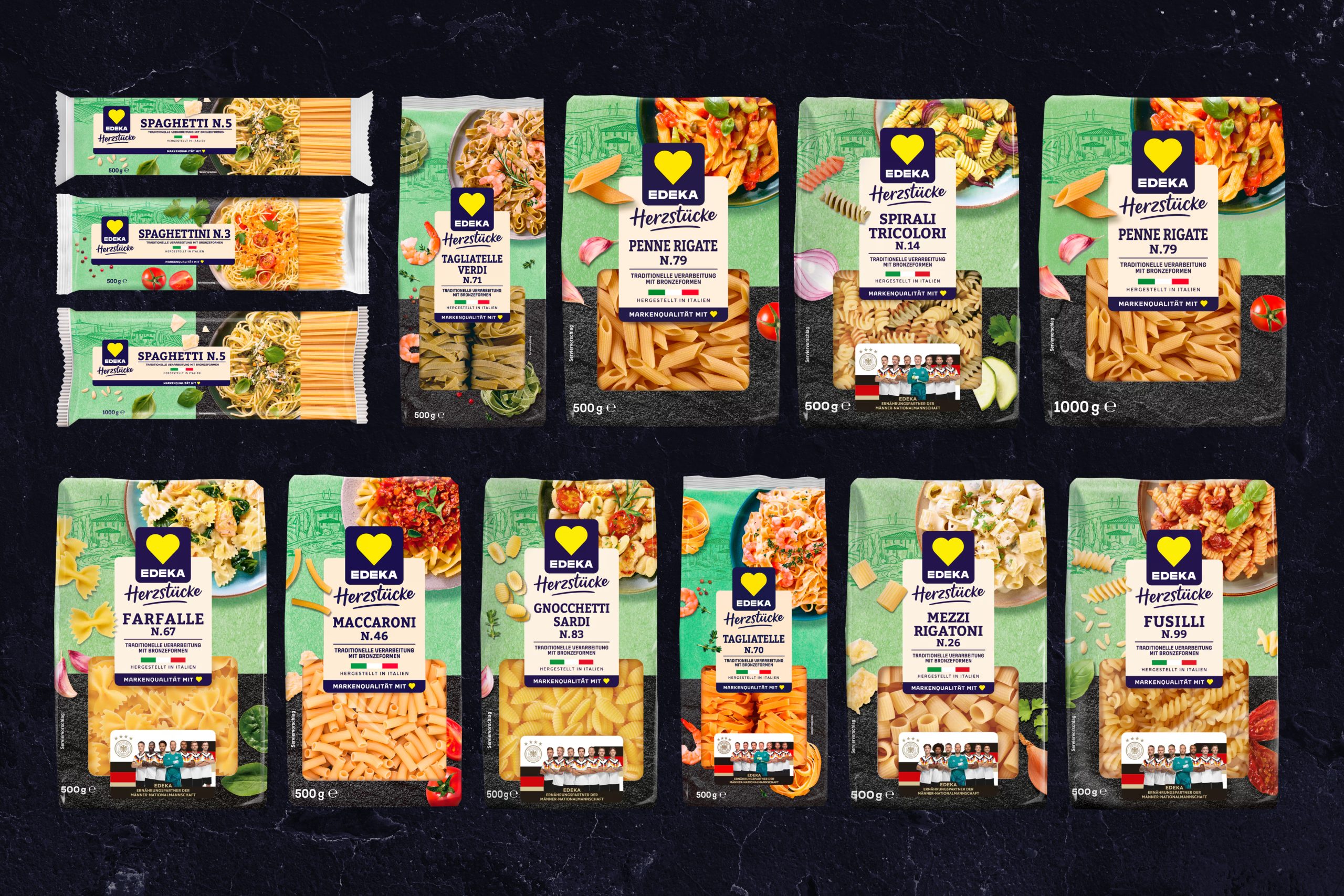 Edeka Herzstücke. 13 unterschiedliche Pasta Verpackungen nebeneinander frontal fotografiert auf schwarzem Grund.