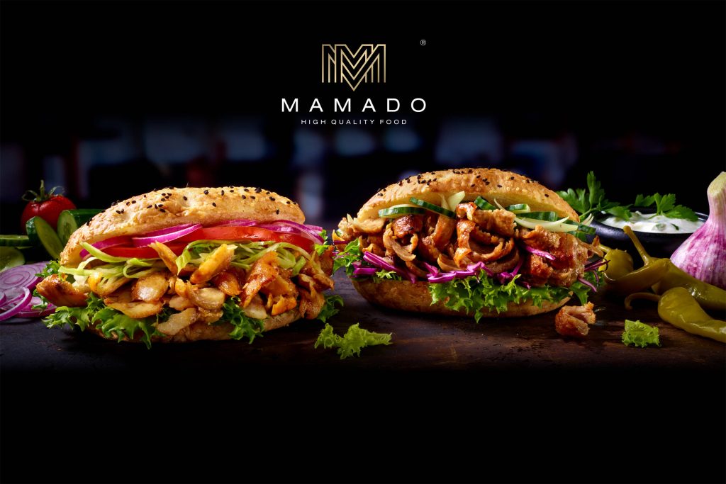 Mamado: Döner-Fleisch in zwei Burgerbrötchen mit Salatblättern, Gurken- und Tomatenscheiben und roter Zwiebel.