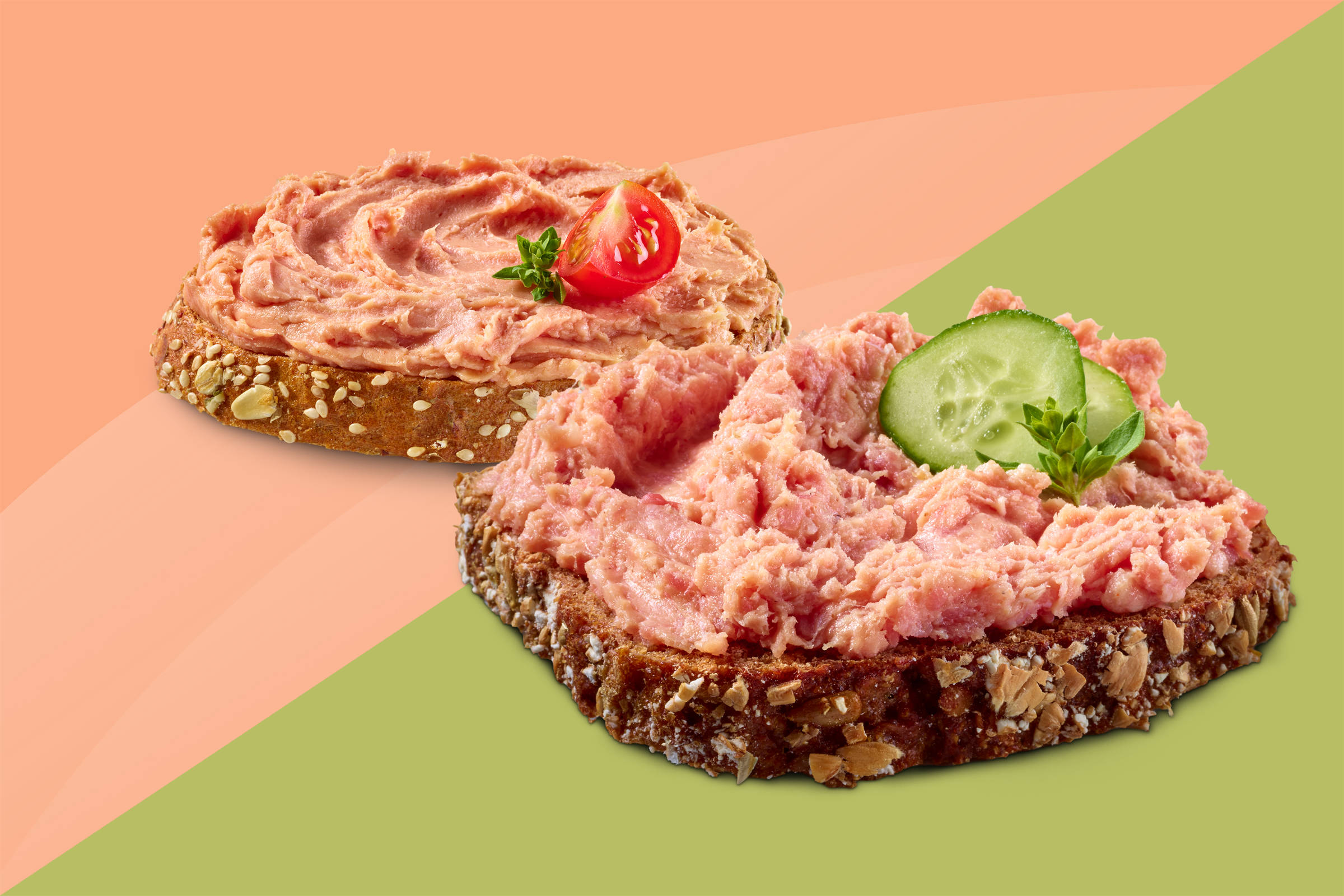 Zwei Scheiben Körnerbrot mit grober Teewurst und Leberwurst, Dekoration aus Gurkenscheiben und Kirschtomate. Hintergrund oben altrosa, unten hellgrün - diagonal getrennt.