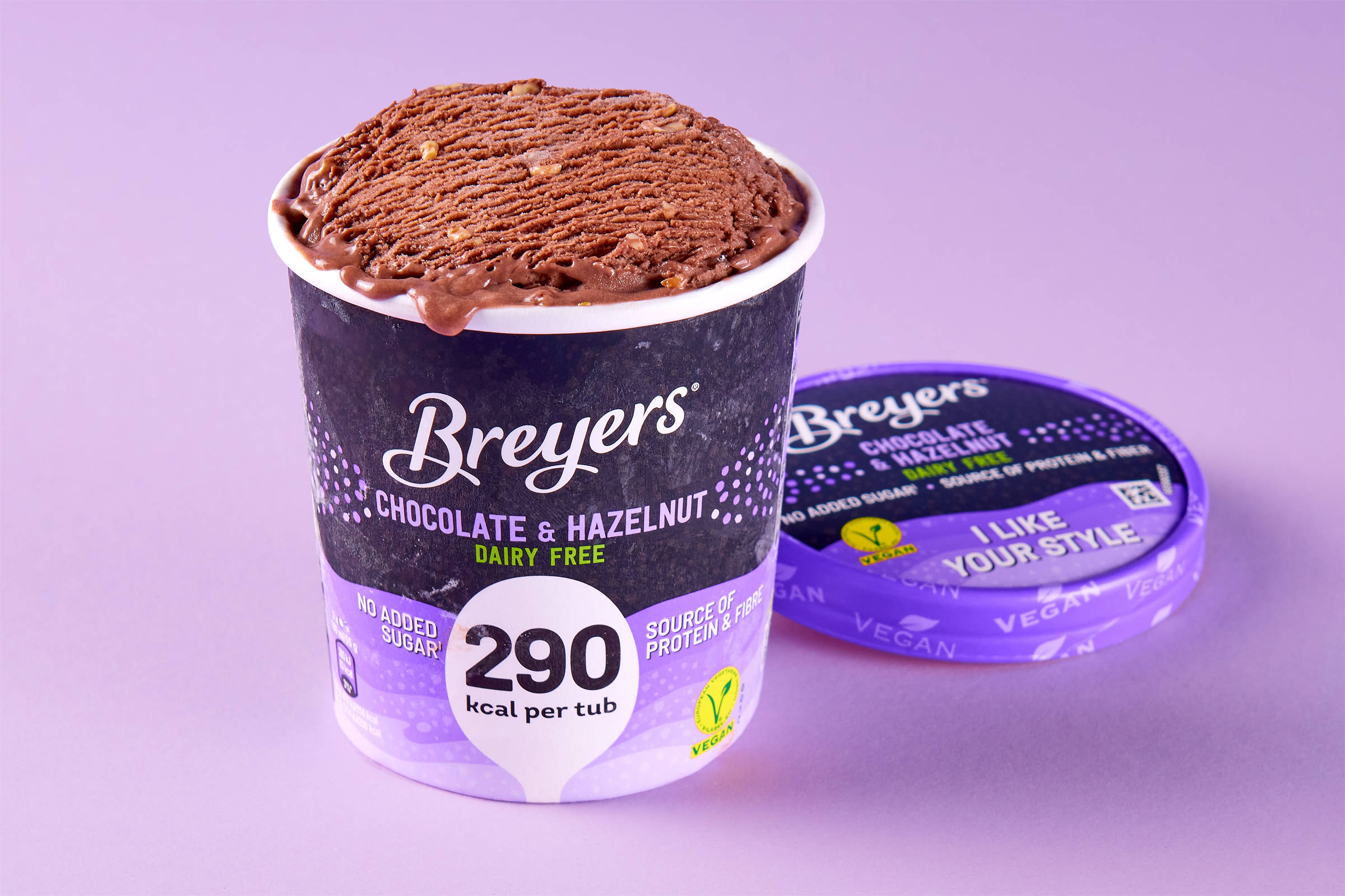 Ein offener Behälter mit Breyers veganer Eiscreme Chocolate & Hazelnut. Auf helllila Untergrund im Verlauf.