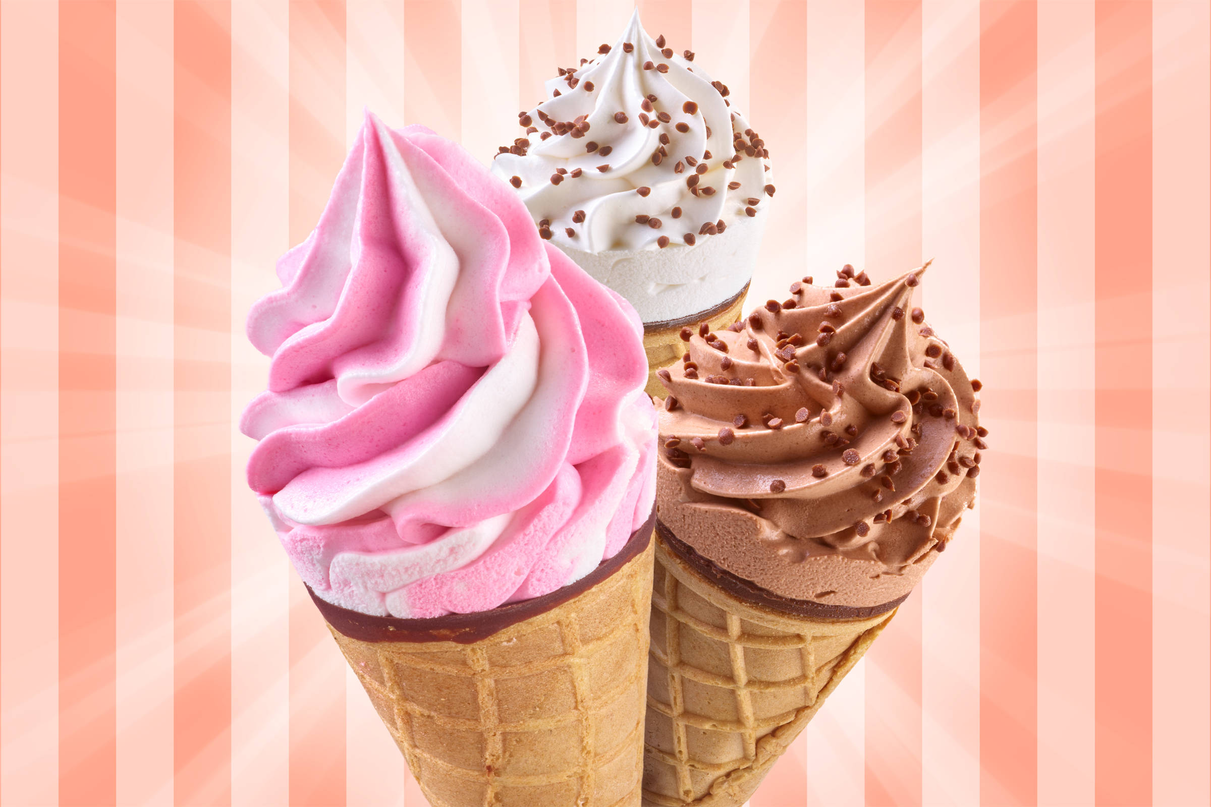 Drei Softeis in je einer Waffel: rosa Himbeer/ Erdbeer link, Vanille mittig, Schokolade rechts. Alles vor einem rötlich-rosa gestreiften Backdrop.